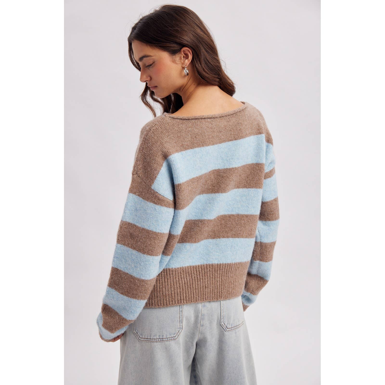 Detail of the ribbed cuff on the sleeve of the brown and sky striped relaxed fit sweater