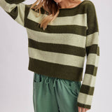 Front view of the relaxed fit striped sweater in brown and sky blue worn untucked over pants