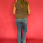 Full length view of the mocha sheer plisse mock neck blouse tucked into tailored trousers