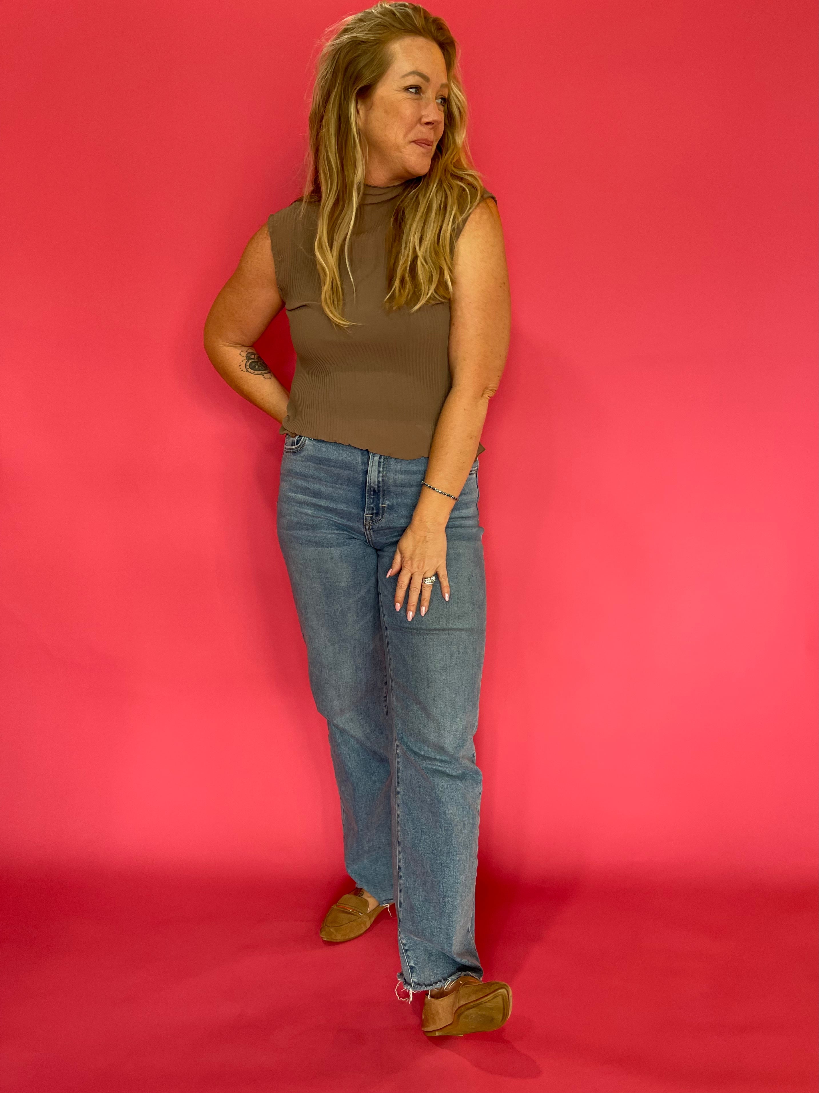 Side view showing the armhole, mock neck, and easy relaxed fit of the mocha plisse blouse
