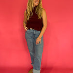 Side view showing the sleeveless armhole and lightweight fall of the oxblood blouse