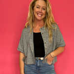 Woman wearing a heather grey short sleeve knit top with a functional button front
