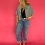 Grey short sleeve knit top tucked into tailored trousers for a polished office look