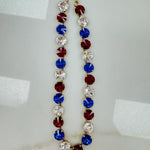 Antique gold plated Tova Sofia necklace set with multicolor 4th of July mix crystals on a plain backdrop