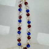 Antique gold plated Tova Sofia necklace set with multicolor 4th of July mix crystals on a plain backdrop