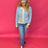 Side view of the contrast stripe sweater half tucked into light wash denim jeans
