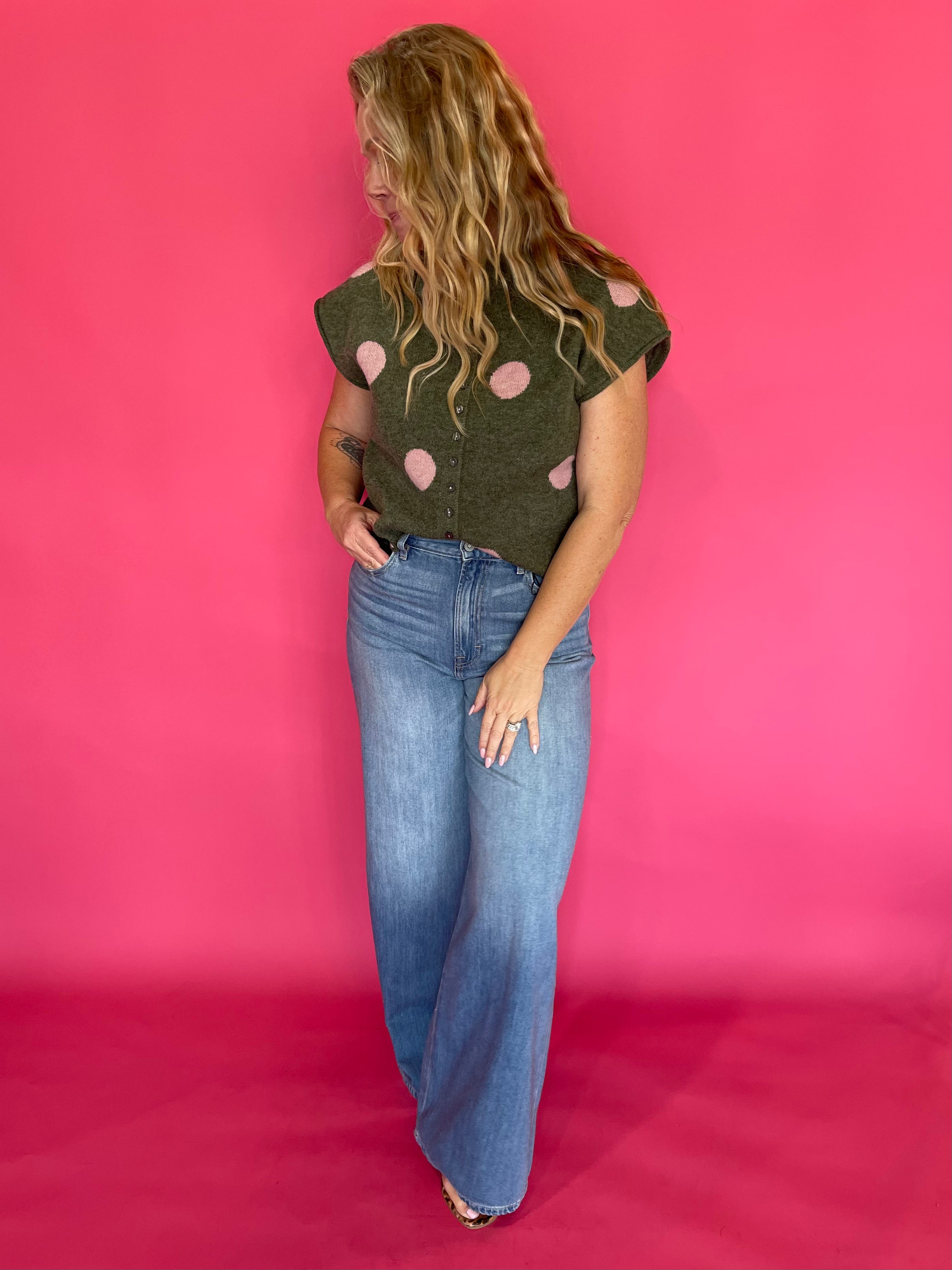Close-up of the collar and button front placket on the olive green polka dot sweater top