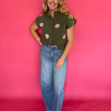 Side view of the cropped olive knit top showing the rolled short sleeve and high hip hem