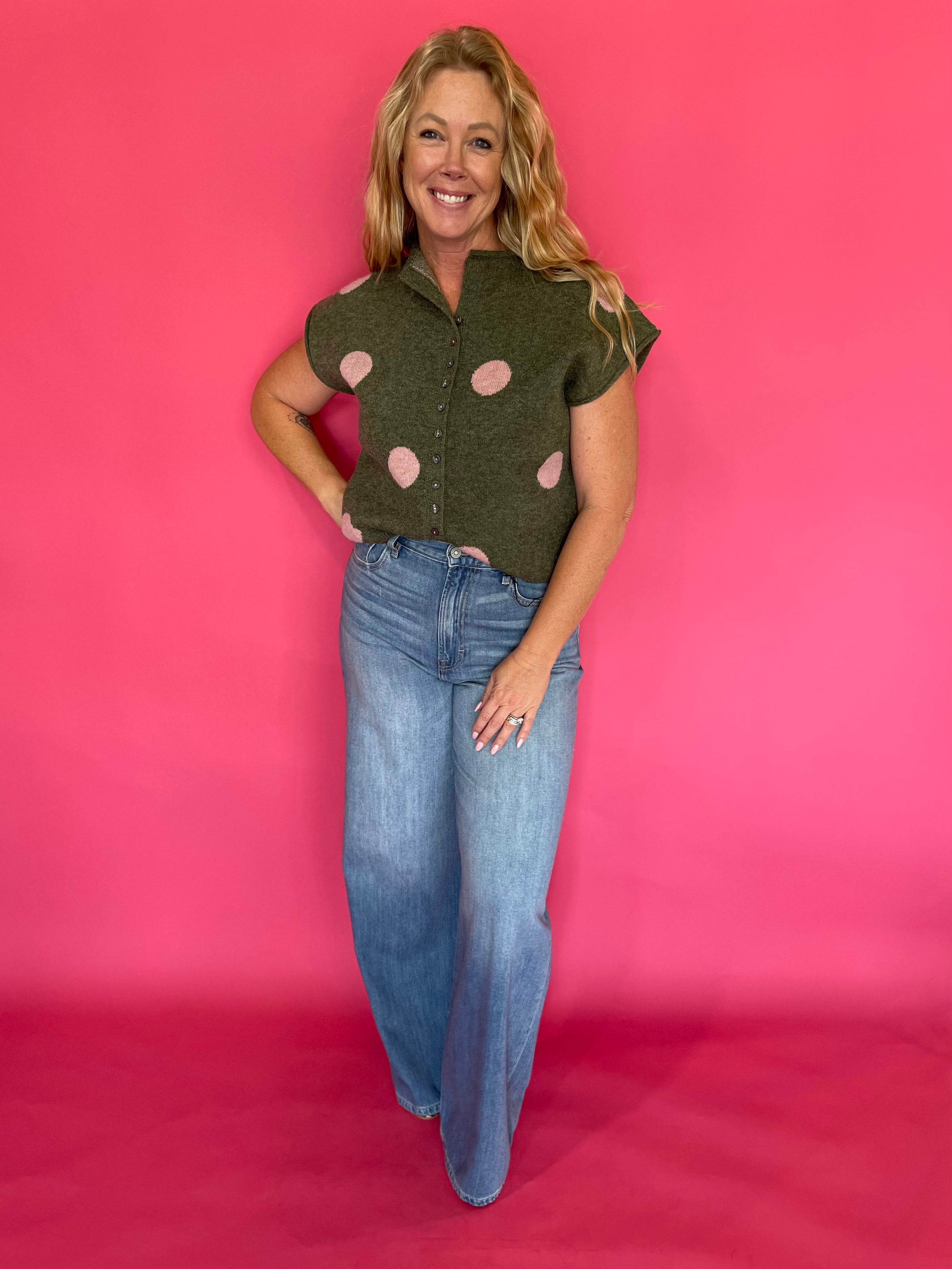 Side view of the cropped olive knit top showing the rolled short sleeve and high hip hem
