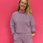 Woman wearing a mulberry and cream striped cropped French terry crewneck with matching shorts