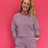 Woman wearing a mulberry and cream striped cropped French terry crewneck with matching shorts