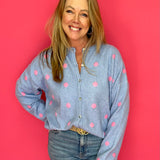 Woman wearing a blue shirt with pink polka dots against a red background