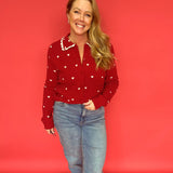 Close-up of the scalloped heart collar and button placket on the red heart print sweater
