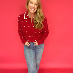 Flat lay of the red heart print sweater showing the scalloped collar and button front