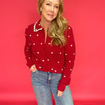 Woman wearing a red all-over heart print button-up sweater with a scalloped heart collar