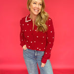 Woman styling the heart print button-up sweater open over a tank with high-rise denim