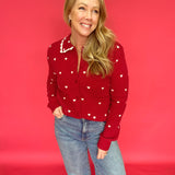 Woman styling the heart print button-up sweater open over a tank with high-rise denim