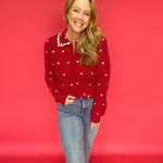 Detail of the all-over heart print and functional buttons on the soft nylon knit sweater