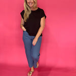 Side view showing the polished drape and short sleeves of the black scuba knit top