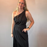 Full length view of the black one-shoulder dress styled with heels for an evening event