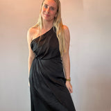 Flat lay of the black one-shoulder midi dress showing the asymmetrical neckline and draped bodice