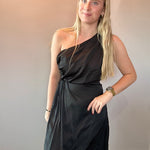 Detail of the lightweight woven fabric and soft movement in the skirt of the black midi dress