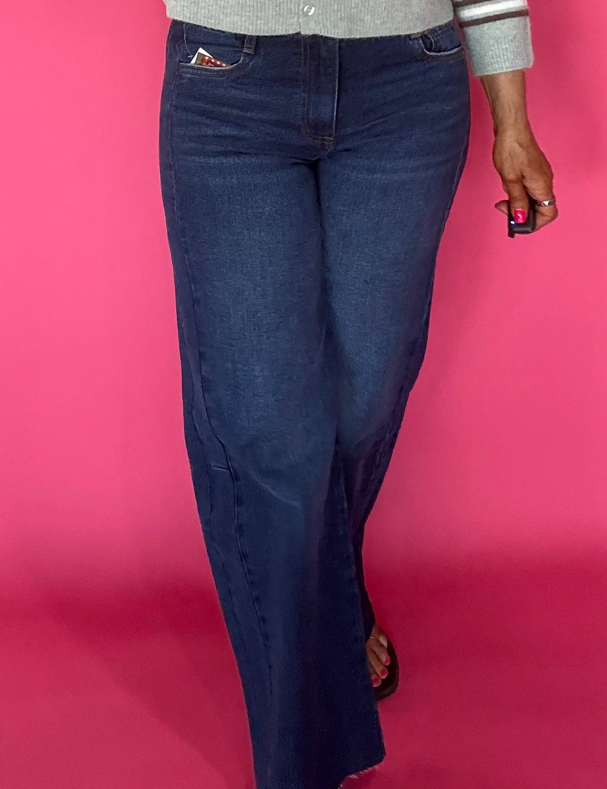 Woman wearing Curator wash wide leg jeans with a raw hem and a fitted tee tucked in