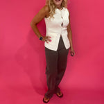 Close-up of the button front placket and functional pocket on the ivory sweater vest