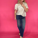 Detail of the pintucked texture and soft drape on the lightweight neutral oatmeal woven blouse