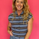 Woman wearing a blue and white striped sleeveless top with denim and white sneakers