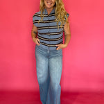 Side view of the blue striped top tucked into tailored trousers with loafers for work