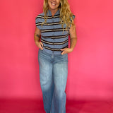 Side view of the blue striped top tucked into tailored trousers with loafers for work