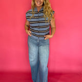 Side view of the blue striped top tucked into tailored trousers with loafers for work