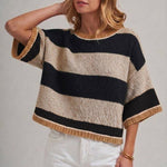 Side view of the wide stripe drop shoulder sweater in blue and brown, worn loose over the hip