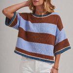Woman wearing a blue and brown wide stripe drop shoulder sweater top in a loose, easy everyday fit