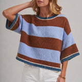Woman wearing a blue and brown wide stripe drop shoulder sweater top in a loose, easy everyday fit
