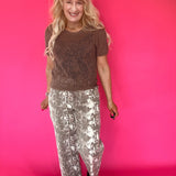 Detail of the elastic waistband and gathered front of the ecru snake print pants