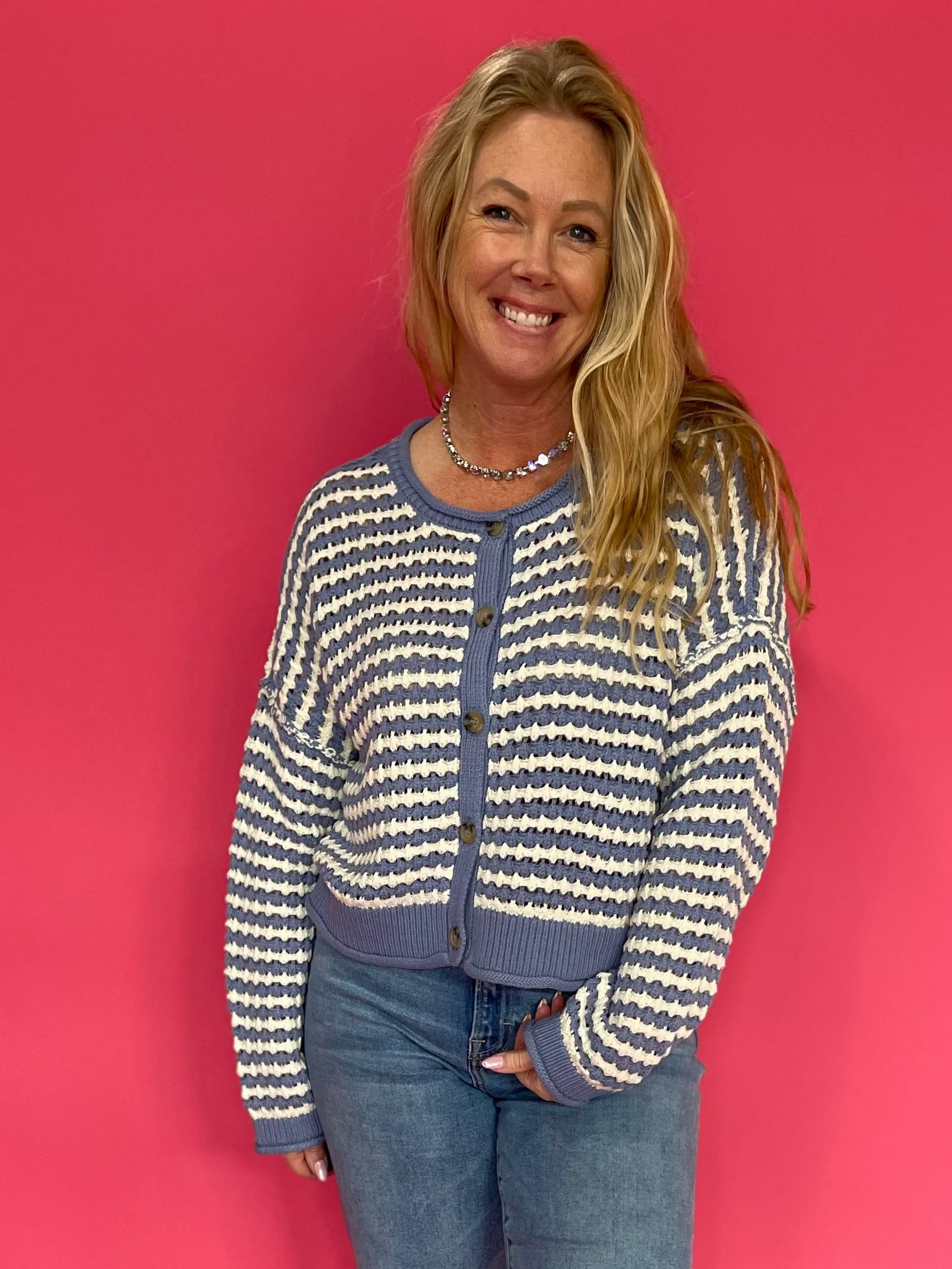 Woman wearing a chocolate brown soft knit sweater with a relaxed everyday fit and blue jeans