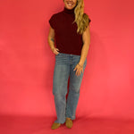 Wine ribbed mock neck sweater layered over a collared shirt with trousers for the office