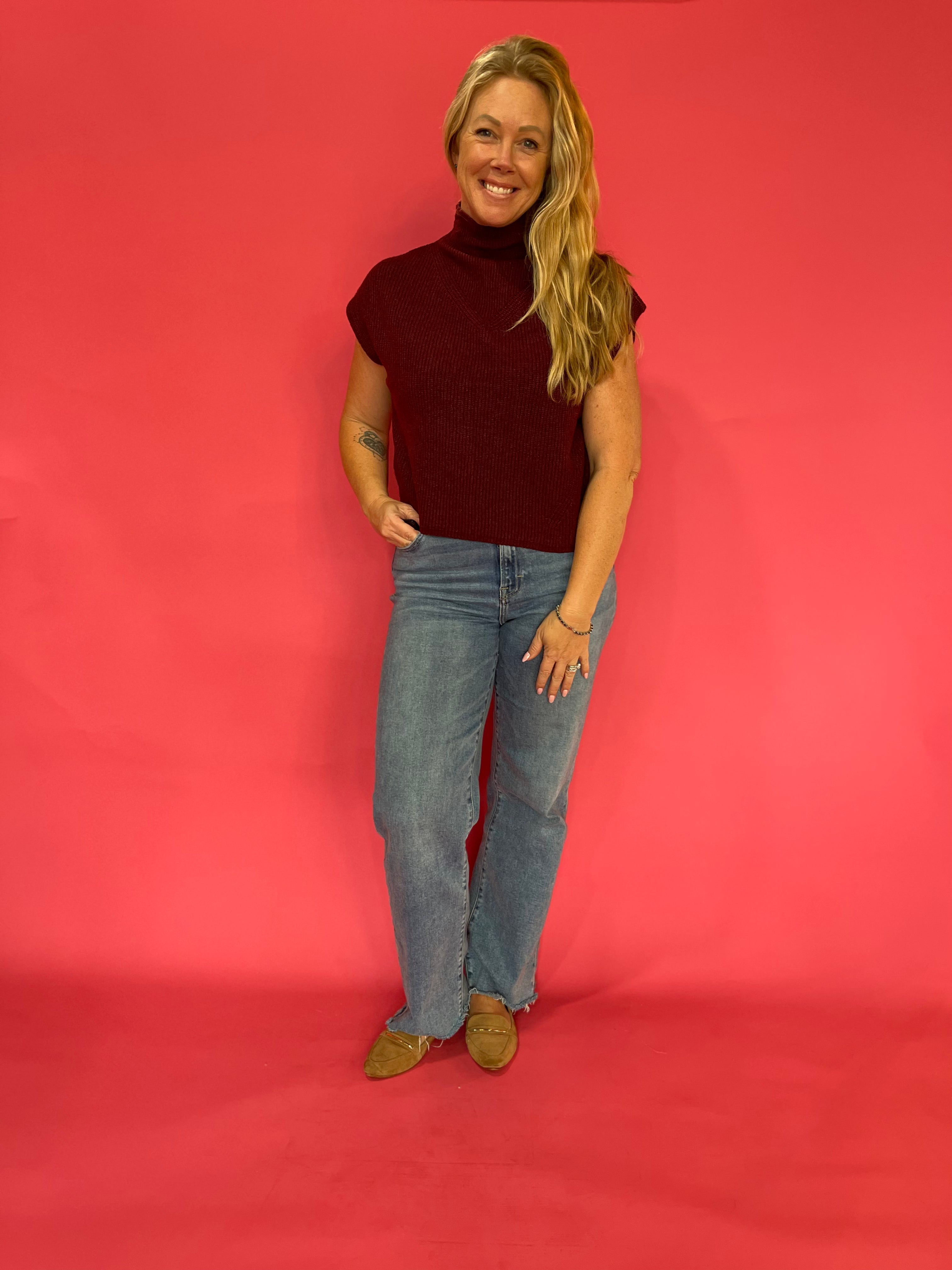 Wine ribbed mock neck sweater layered over a collared shirt with trousers for the office