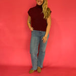 Wine ribbed mock neck sweater layered over a collared shirt with trousers for the office